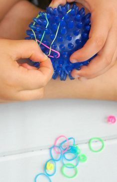 Here is a simple fine motor activity using a spiky ball and loom bands. It's lots of fun for preschoolers or children needing to build their hand muscles for writing and gripping objects. Occupational therapist would also be very interested in this easy idea for kids. Fine Motor Activity, Fine Motor Activities For Kids, Occupational Therapy Activities, Counseling Office, Activities Ideas, Preschool Fine Motor, Quiet Activities, Fine Motor Skills Activities, Motor Skills Activities