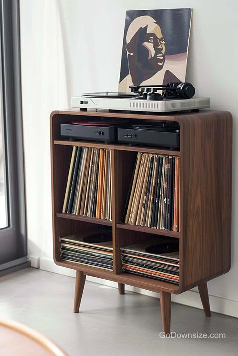 This wooden feature follows a common midcentury design shape and remains standard with a straightforward layout. Home Turntable Setup, Vinyl Record Nook, Hifi Cabinet Ideas, Mid Century Modern Vinyl Record Storage, Audio Racks And Stands, Record Set Up, Record Player Corner, Vinyl Player Setup, Turntable Decor