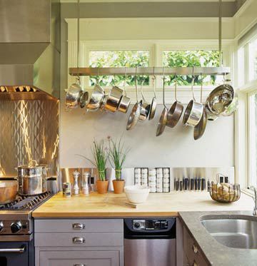 Free up some good cabinet space and get your pots dangling from the ceiling. You don’t need a huge kitchen to do this. I love how this tight kitchen simply places the pots just along the wall. It brightens up the space too as the light from the window reflects off the silver pots. Your eyes are directed upward too–which makes the entire space feel bigger even if you have a low ceiling. Pot Rack Kitchen, Pan Storage, Pot Rack Hanging, Kitchen Pot, Kitchen Upgrades, Pot Rack, Hanging Pots, Hanging Racks, Stylish Kitchen