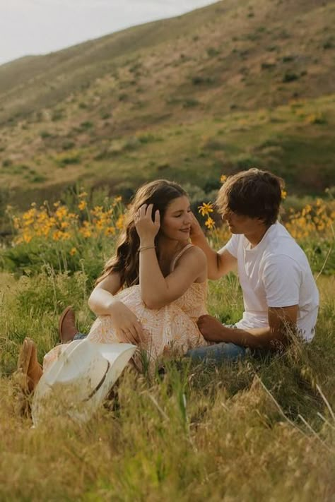 A couples shoot turned proposal on the green hillsides of Lucky Peak in Boise, Idaho. Boise Idaho Engagements || hillside engagements || lakeside engagements || spring proposal || summer proposal || mountain proposal || nostalgic engagement session || timeless engagement session || wildflower field engagement session || summer engagement session outfit Late Summer Couples Photoshoot, Engagement Photos Outside Spring, Flower Farm Engagement Photos, Engagement Photos Grass Field, Field Photoshoot Engagement, Couple In Field Photography, Engagement Photos With Flowers Bouquets, Wildflower Field Engagement Photos, Flower Field Proposal