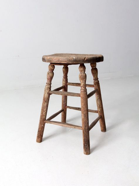 "This antique wooden farmhouse stool exudes rustic charm with its turned legs and subtle traces of cream paint. Its round wood seat boasts an old repair that adds character to the piece. CONDITION In good, sturdy condition with wear consistent with age and use. Old repair on base to secure splits in seat top. General wear to the finish.  MEASUREMENTS Height:  21\"  ..  53.3 cm Width:  14.5\"  ..  36.8 cm Depth:  14.5\"  ..  36.8 cm SHIPPING Standard shipping via ground service.  Delivery estimate in 2-5 weeks. Faster shipping available as upgrade in checkout.  International and non-contiguous US customers, please contact us for shipping options and pricing based on your location. 1023153" Wooden Stool Side Table, Book Bus, Old Wooden Chairs, Farmhouse Stools, Wooden Farmhouse, Stool Cushion, Cream Paint, Vintage Stool, Wooden Stool