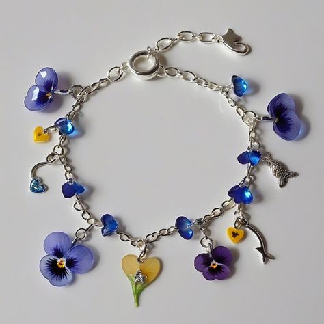 Gorgeous Resin Pansy Flower Bracelet: Nature's Beauty on Your Wrist! 🌸✨" "Adorn your wrist with the exquisite beauty of nature! 🌿 Our handcrafted resin pansy flower bracelet is a stunning accessory that captures the delicate elegance of blooming pansies. Each petal is meticulously crafted to preserve its vibrant colors and intricate details, making every piece truly unique. Whether you're adding a pop of color to your everyday ensemble or searching for the perfect gift for a nature lover, t... Resin Polymer Clay, Pansy Flower, Resin Bracelet, Real Flower Jewelry, Pansies Flowers, Delicate Beauty, Resin Flowers, Statement Bracelet, Flower Bracelet