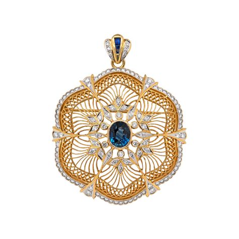 This incredibly detailed openwork floral brooch/pendant showcases a deep blue oval shaped sapphire, weighing an estimated 4.00ct set centrally in an open back, rub over setting. The sapphire is beautifully surrounded by floral designed decorations embellished with fine quality round brilliant cut diamonds and further adorned with lace-like openwork gold, leading to a diamond set scalloped edge. The flower perfectly hangs from a solid scalloped shape bail, set with a row of 3 channel set blue sap Diamond Cat, Retro Bracelet, Edwardian Jewelry, Floral Brooch, Emerald Pendant, Gold Brooches, Channel Set, Sapphire Jewelry, Diamond Set