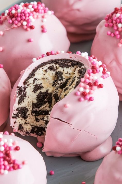 Close-up of an Oreo truffle ball cut in half, highlighting the creamy, Oreo-filled center and pink candy shell topped with pink, white, and red sprinkles. Perfect for romantic or festive occasions. Keywords: Oreo truffle close-up, pink sprinkle toppings, festive dessert ideas, Oreo and cream cheese filling, eye-catching desserts. Pink Treats For Birthday Party, Pink Oreo Balls, Baby Shower Treats Girl, Pink Treats For Party, Pink Truffles, Oreo Truffle Balls, Pink Oreos, Birthday Cake Truffles, Truffle Balls