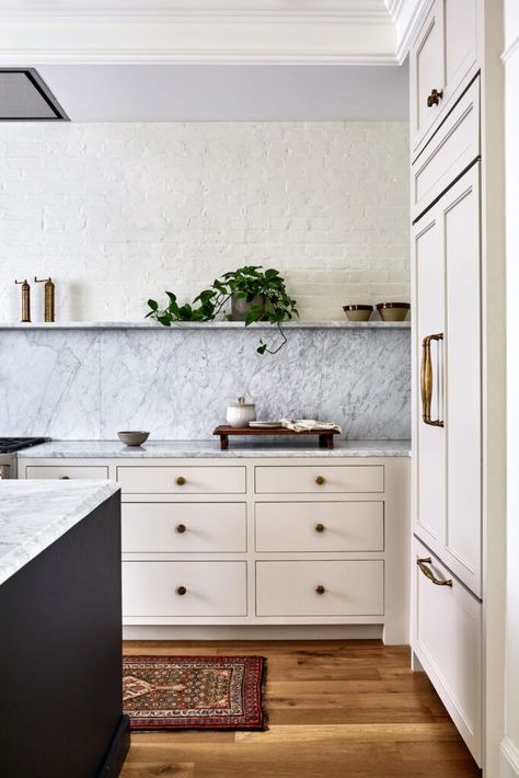 The single marble ledge runs along the entire length of the wall, serving as both storage for everyday items or as a means to exhibit artwork. The marble extends to the backsplash and countertops to create a seamless and timeless feel. The unexpected star is the smooth brass sink. Soapstone Countertops Marble Backsplash, Stone Shelf Kitchen, Gray Countertops Kitchen, Victorian Row House, Designer Nightstand, Marble Backsplash Kitchen, Stone Backsplash Kitchen, Granite Backsplash, Kitchen 2024