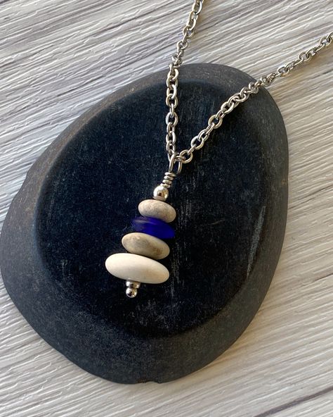 Cairns have long been used to mark trails and paths so that we don’t lose our way in the wilderness. Take a little bit of the trail with you wherever you go with this dainty cairn necklace. Three hand drilled pebbles and a heishi glass bead are hung on small stainless steel chain. Comfortable and easy to wear. Stainless steel chain and findings won’t tarnish, and won’t irritate sensitive skin. -Stainless steel findings and chain -Hand drilled natural beach pebbles and an indigo glass heishi bead Cairn Necklace, Beach Pebbles, Heishi Necklace, Blue Flats, Heishi Beads, Cairns, The Wilderness, The Trail, Steel Chain