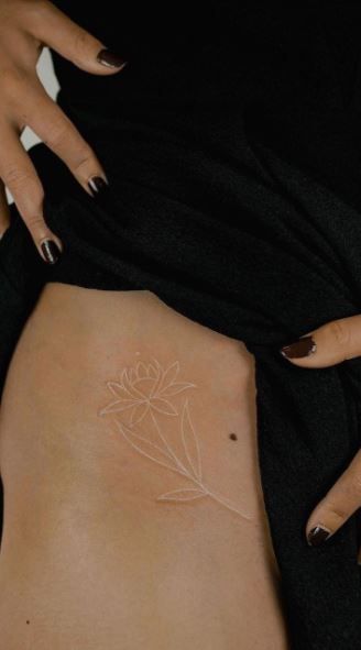 Hip Tattoos Women White Ink, White Ink Back Tattoo Women, White Collarbone Tattoo, Tattoo Ideas Female White Ink, White Ink Spine Tattoo, Wrap Around Rib Tattoo, White Hand Tattoos For Women, Small Inner Thigh Tattoos, White Tattoo Flower