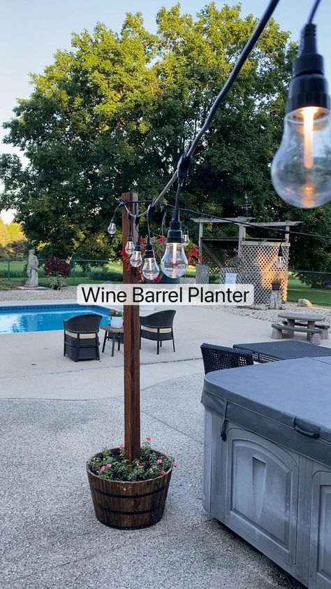 Wine barrel planter | Wine barrel planter, Backyard patio designs, Barrel planter Patio Buckets With Lights, Outdoor Barrel Planter Ideas, Permanent Campsite Decorating Ideas, Backyard Decorating Ideas Diy, Driveway Decorations, Poolside Decorating Ideas, Pergola Decorating Ideas, Backyard String Lights, Wine Barrel Planter