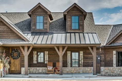 Product Use:  Wire Brushed ranchwood™ in Western color using square edge trim in 1x3, 1x6, 1x8, square edge lap siding in 1x8 and 1x6 tongue and groove soffit and porch overhang material.  10x10x10 posts, 6x6x10 timber frame accents in the gables.  Combining stone with wood square edge lap siding creates a beautiful exterior on this lake side home.  The timber in the gables provide a great accent to the finishing details of this home.  Each component from the soffits to siding work to create a r Stone And Wood Home Exterior, Faux Log Siding Exterior, Timber Exterior House, Western Cabin Exterior, Wood Lap Siding Exterior, Wood Looking Siding Exterior, Farmhouse Cabin Exterior, Wood Look Metal Siding, Modern Cabin Exterior Design