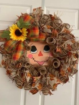 Lady Scare Crow made with Beige and brown ruffles and curls . Fall colors plaid ribbon tails. Fall color leaves ribbon tails. Brown and beige raffia accent. 10" round birch wood hand painted scare crow face. Lady is adorned with a beautiful 10" bow with with a sunflower.   Display for fall and Thanksgiving on your front door or favorite wall . 25" in diameter and 6" in depth. Sunflower Display, Diy Fall Wreaths, Scare Crow, Scarecrow Crafts, Fall Deco Mesh Wreath, Fall Deco Mesh, Color Leaves, Scarecrow Wreath, Fall Scarecrows