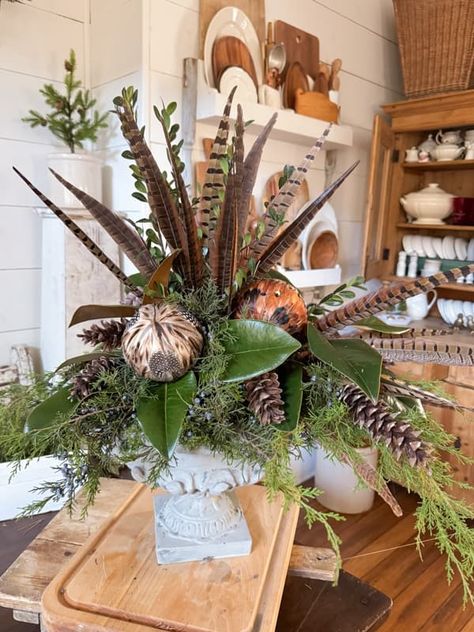 Create A Rustic-Chic Greenery and Pheasant Feather Centerpiece Christmas Tree Pheasant Feathers, Pheasant Tail Feathers Decor, Pheasant Flower Arrangements, Pheasant Tail Display, Pheasant Feather Crafts Diy, Pheasant Feather Centerpieces, Crafts With Feathers, Pheasant Wedding, Fall Dinner Table Decor