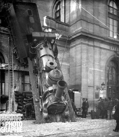 The Montparnasse derailment occurred on October 22, 1895 when the train overran the buffer stop at its Gare Montparnasse terminus. With the driver trying to make up for lost time, it entered the station too fast and the train air brake failed. The train crashed through the station wall; the locomotive fell onto the Place de Rennes below, where it stood on its nose. A woman in the street below was killed by falling masonry. The engineer was fined 50 francs and one of the guards 25 francs. Paris Train, Montparnasse Paris, Paris October, Train Crash, Runaway Train, Air Brake, Train Wreck, Old Paris, Old Trains