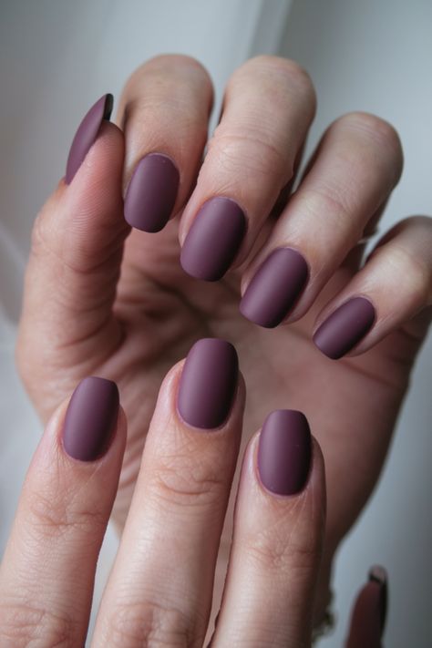 Embrace the season with this stunning matte plum nail design! Perfect for fall fashion lovers, this trendy, minimalist look brings a touch of elegance to your nails. The rich, muted tone is ideal for autumn and pairs beautifully with any cozy fall outfit. Get inspired by this chic fall nail idea and elevate your style with this simple yet sophisticated design! Soft Autumn Nails Color Palettes, Matte Plum Nails, Fall Season Nails Short, Autumn Matte Nails, Matte Fall Nails Short, Dark Purple Nails Designs, Dusty Purple Nails, Plum Fall Nails, Fall Nails Purple