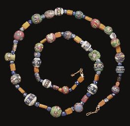 A ROMAN GLASS MOSAIC BEAD NECKLACE  1ST CENTURY A.D.  Composed of thirty-two beads in bright colors, spherical, disk-shaped, rectangular and drop-shaped, seventeen with faces, three encircled by lotus flowers, two with petalled flowers, two with Nilotic birds in profile, one millefiori bead, and eight with geometric designs, on a green, white, red or blue ground, interspersed with rectangular opaque orange glass beads and small, spherical blue and white millefiori beads; 32 1/8 in. (82 cm.) long Roman Glass Beads, Roman Necklace, Ancient Necklace, Ancient Roman Jewelry, Millefiori Beads, Ancient Beads, Ancient Jewels, Green White Red, Roman Jewelry