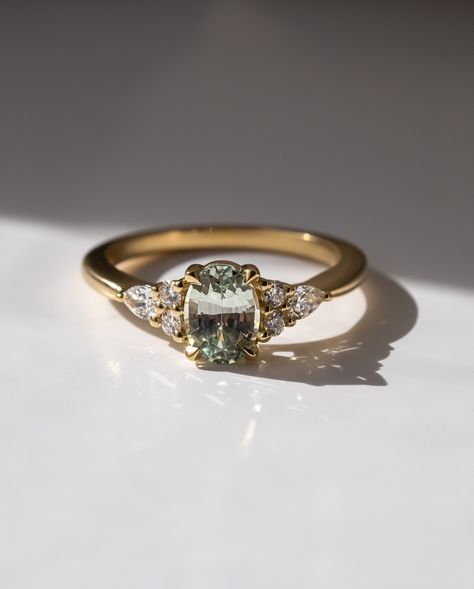 THE NANAMI🤍 Oval cut green sapphire Pear and round side diamonds 1.3ct centre stone 18k Recycled gold 6 - 8 weeks to craft from order Ships worldwide Handmade in London💕 #ovalcut #ovalcutengagementring #ovalcutdiamond #greensapphire #londonjeweller #engaged #engagementring Unique Engagement Rings Vintage Antiques, Nature Inspired Engagement Rings, Green Engagement Rings, Nature Inspired Engagement Ring, Antique Engagement Rings Vintage, Vintage Engagement Rings Unique, Oval Cut Engagement Ring, Green Sapphire, Oval Cut Diamond