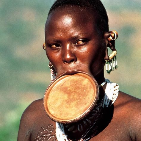 African Ceremonies on Instagram: “"A #Surma #bride from #Ethiopia wears a clay lip plate inserted six months before marriage. The size of the plate indicated the number of…” Suri Tribe, Mursi Tribe, Brass And Copper, Before Marriage, Lip Piercing, A Level Art, Copper Rings, Book Inspiration, Beaded Tassels