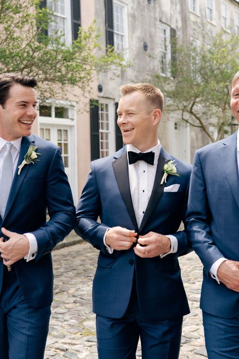 Groom in navy blue tuxedo laughing with groomsman on cobblestone street in downtown Charleston. Classy wedding outfit ideas. Charleston wedding outfit ideas. Southern groom ideas. www.kaileedimeglio.com Husband and wife photography team. wedding photography. luxury destination wedding photographer. kailee dimeglio photography Groomsmen Blue Tuxedo, Navy Groom Tuxedo, Navy Tuxedo Wedding Groomsmen, Navy Wedding Tux Groom, Navy And Black Groomsmen, Spring Tuxedo Wedding Grooms, Navy Blue Tux Wedding, Groom And Groomsmen Attire Blue, Blue Tuxedo Prom