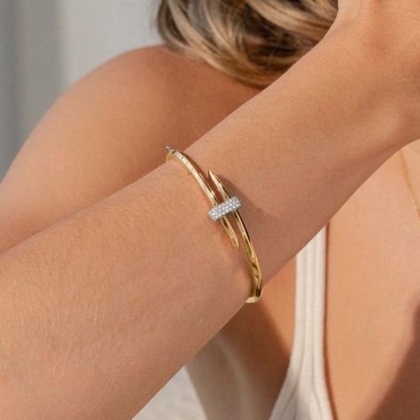 Embrace the challenge with this Iconic Ecksand gold wrap bangle that encapsulates the art of fencing. Its high-end gold spirals around the wrist taking after the minimalist lines of an épée, and united by a glistening diamond pavé in white gold mimicking armour. Boasting sharp edges and clean lines, this distinctive jewel is made to impress. Accent diamonds: 0.25+ ctw, VS2+/F+Setting: Grain setting Bracelet Gold And Diamond, High End Accessories, Diamond And Gold Bangles, Good Bangles Design, Ring Designs Gold, Gold Bangle Design, Gold Diamond Bangles, Gold And Diamond Bracelet, Minimalist Bangle