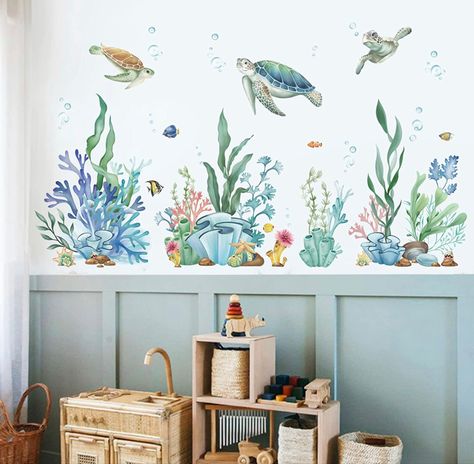 A blue nursery with ocean theme wall stickers on the wall. Coral Reef Themed Bedroom, Ocean Wall Stickers, Ocean Gender Neutral Nursery, Under The Sea Wall Decals, Underwater Nursery Theme Girl, Under The Sea Bathroom Ideas Kids, Under Water Nursery Theme, Aquarium Nursery Theme, Under The Sea Girls Bedroom