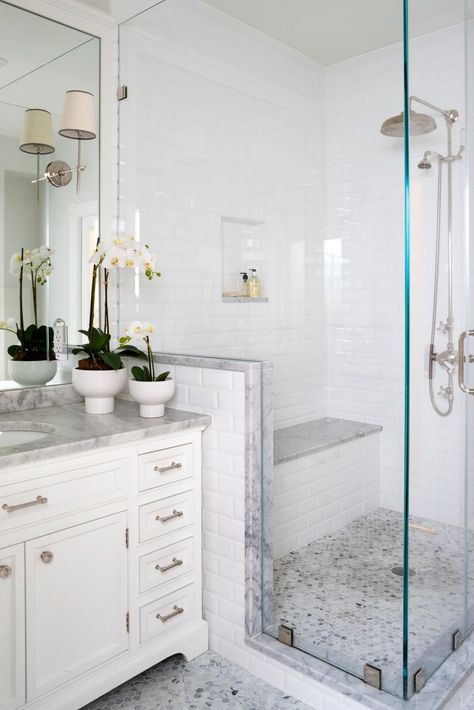 A glass-enclosed shower is fitted with a bench is this traditional master bathroom space. The potted flowers on the vanity are also seen in the kids' bathroom, adding continuity between the spaces. Minimalist Small Bathrooms, Makeover Kamar Mandi, Beautiful Master Bathrooms, Small Bathroom With Shower, Shower Bathroom, Bathroom Curtain, Bathroom Shower Tile, Bathroom Remodel Shower, Curtain Bathroom