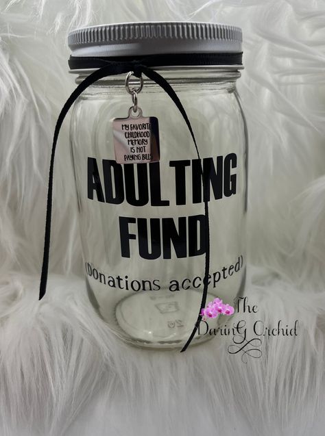 "Who said adulting was easy? This cute jar will remind you to drop your change or spare bills in it and make saving a little more fun. It might even entice your guests to make a donation 😊 Clear glass Jar is 16 ounce size, approximately 3\" in diameter and 5\" tall with silver color screw on lid with slot. Your choice of ribbon colors, pictured with black ribbon and stainless steel charm that reads \"my favorite childhood memory is not paying bills\" This item can be personalized, If requesting personalization please add it in the notes section. Now available in quart size jars!" Money Saving Jars Ideas Diy, Cute Tip Jar Ideas For Work, Money Jar Ideas, Disney Savings Jar, Welcome To Adulthood, Goth Apartment, Disney Savings, Jar Decorations, Money Saving Jar