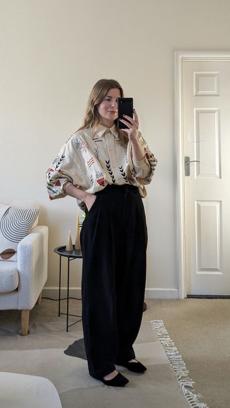 A woman stands in front of a mirror. She wears an oversized embroidered shirt with wide leg black trousers and black Mary Jane shoes. Wide Leg Trousers Shoes, Wide Legged Black Pants Outfit, Wide Black Trousers Outfit, Wide Trousers Outfit Winter, Oversized Black T Shirt Outfit, Comfy Oversized Outfits, Wide Trousers Outfit, Trousers Outfit Winter, Black Slacks Outfit