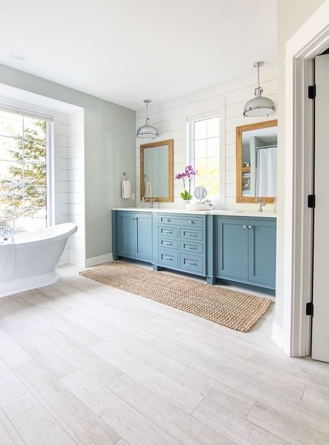 Oct 16, 2019 - white and blue lake house master bathroom. Blue cabinets, white countertops and faux wood floor tile give a coastal feel to this lake house bathroom. Lake House Master, Traditional Bathroom Lighting, Faux Wood Flooring, Lake House Bathroom, House Of Turquoise, Coastal Bathrooms, Blue Cabinets, White Countertops, Blue Bathroom