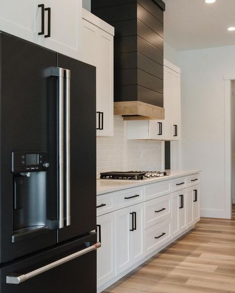 Cafe Appliances on Instagram: "A mix of modern and cozy is one of our favorite combos 🤍 @ic_construction_lc #distinctbydesign . . . Homes with contrast and character, check out this cozy modern farmhouse with all the details!!!! #blackandwhitekitchen #kitchendesign #kitchensofinstagram #cafeappliances #lvp #shiplap #icconstruction #nflbuild #customhomebuilder #barndoors #quartzcountertops (via @ic_construction_lc)" Black Hood Kitchen White Cabinets, Modern Farmhouse Kitchen With Black Stainless Steel Appliances, Modern Kitchen Black Appliances, Black Appliances White Kitchen, Matte Black Cafe Appliances, Modern Kitchen With Black Appliances, Black Fridge White Kitchen, Cafe Black Appliances, Black Appliances White Cabinets