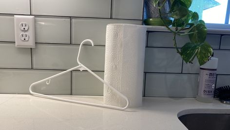 We Tried The Coat Hanger As A Paper Towel Holder Hack And We Can Roll With These Two Perks Kitchen Paper Towel Holder Ideas, Massive Kitchen, Utility Shelves, Kitchen Roll Holder, Reusable Paper Towels, Unpaper Towels, Kitchen Paper Towel, Hanger Diy, Plastic Hangers