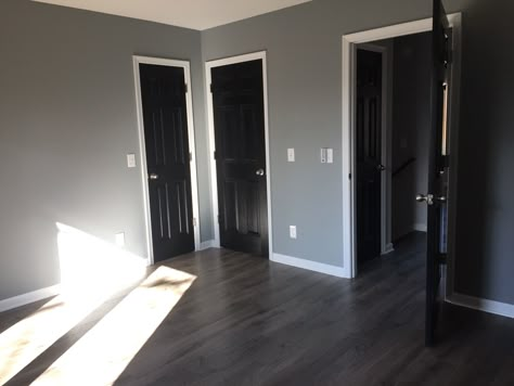 Black interior doors Grey Walls And Black Trim, House Black Doors Interior, Black Doors Interior Grey Walls, Black Walls Grey Floor, Gray Walls And Black Doors, Black Interior Doors Grey Walls, Black Interior Doors With Gray Walls, Black Panel Doors Interior, Black Grey And White Hallway