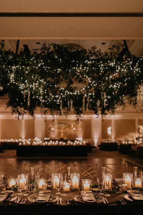 Glowy evening wedding reception with stunning lush greenery installation and romantic candlelit tablescapes at elegant ballroom bash at Nemacolin in Farmington, Pennsylvania. Dream turned reality by Florist- Luxe Creative, Planner- Bumble Burgh Events Co. and Photographer- Rachel Rowland. Romantic Evening Wedding Decor, Wedding Ballroom Lighting, Romantic Greenery Wedding Decor, Lush Romantic Wedding, Wedding Ballroom Decorations Receptions, Twinkle Lights Ballroom Wedding, Ballroom Wedding Reception Romantic, Dark Ballroom Wedding, Winter Wedding Ballroom