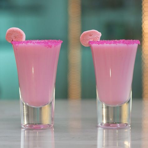 Blow your mind and some bubbles with this Coconut Bubble Gum Shot. This bright pink drink is made of bubble gum-infused rum, piña colada drink, and cream of coconut, and is garnished with pink sugar and a piece of bubble gum. Seriously though, this drink has Bazooka flavor. Pink Barbie Cocktails, Pink Shots Alcohol, Pink Shooters, Starburst Shots, Pink Pina Colada, Pink Shots, Infused Rum, Candy Shots, Girls Night Drinks