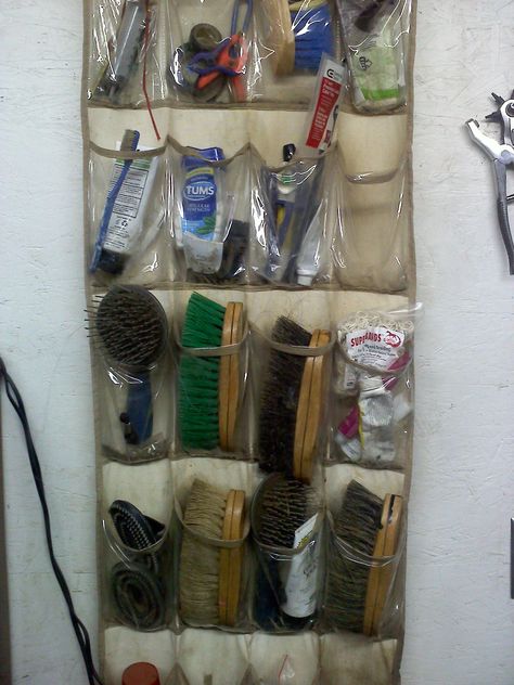 A shoe bag works great to hold brushes, etc at our barn. Tack And Feed Room, Horse Trailer Hacks Tack Rooms, Horse Brush Organization, Horse Organization, Horse Tack Room Organization, Horse Trailer Hacks, Horse Barn Hacks, Horse Barn Organization, Small Tack Room Ideas