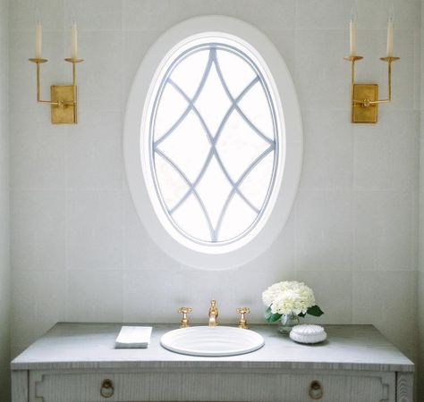 Oval leaded glass window over a gray French sink vanity in a transitional bathroom. Oval Windows, Arte Art Deco, French Vanity, French Bathroom, French Country Bathroom, Oval Window, Round Window, Bathroom Window, Transitional Bathroom