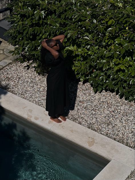 editorial style summer aesthetic outfit picture taken from above of a black woman in a black summer dress holding her braids up and standing by the side of a swimming pool Black Summer Aesthetic, Hamptons Summer, Summer Black Dress, Summer Black, Europe Summer, Black Femininity, Pool Days, Beige Aesthetic, European Summer