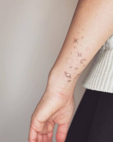 Fine line galaxy tattoo on the wrist. Wrist Galaxy Tattoo, Galaxy Wrap Around Tattoo, Girly Space Tattoo, Space Wrap Around Tattoo, Fine Line Universe Tattoo, Space Wrist Tattoos, Galaxy Fine Line Tattoo, Space Snake Tattoo, Fine Line Earth Tattoo