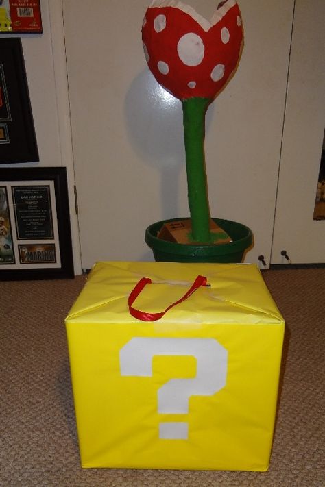 Square boxes wrapped in yellow wrapping paper with "?" on, hanging from ceiling/walls/stacked on floor - Super Mario party Diy Square Pinata, Diy Mario Pinata, Super Mario Pinata Diy, Mario Pinata, Punch Pinata, Mario Ideas, Super Mario Brothers Party, Mario Kart Party, Nintendo Party