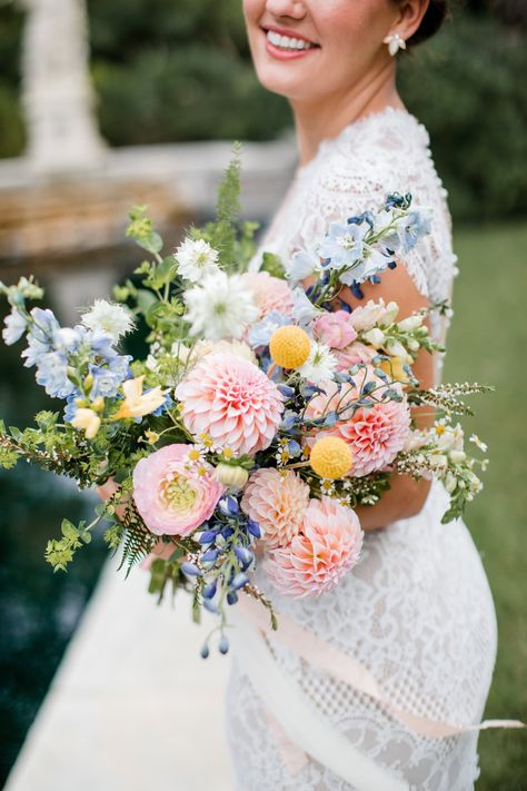 Planning a spring of summer wedding with a subtle pop of color, use this pastel bridle  bouquet as inspiration. The light pink, blue, and yellows make for the perfect spring or summer bouquet. | John Myers Photography & Videography Pink And Blue Wildflower Bouquet, Blue Yellow Pink Wedding, Yellow Wedding Colors Schemes, Pink Yellow Weddings, Cheekwood Wedding, Blue Yellow Weddings, Yellow Bridal Bouquets, Yellow Wedding Colors, Pastel Wedding Colors