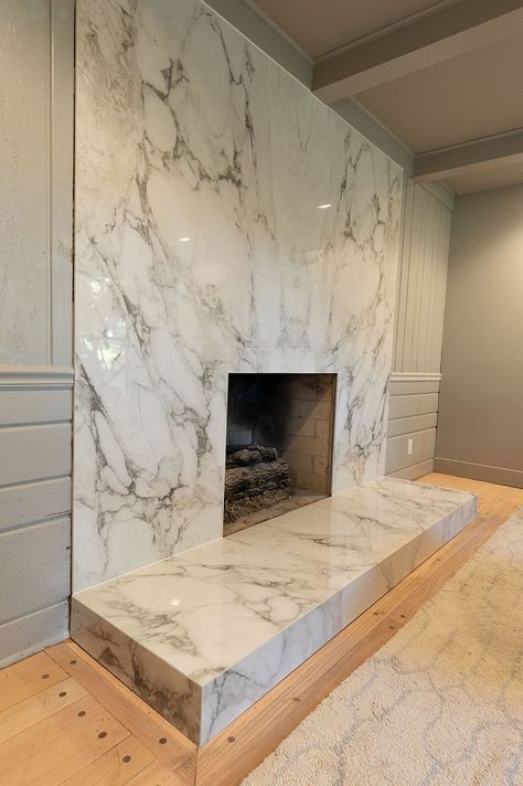 The fireplace is its own piece of artwork since they went with a book-matching technique. The stone they used is Ice Age Porcelain, making it a great option to withstand heat. Modern Porcelain Fireplace, Stone Slab Fireplace, Modern Fireplace Wall, Quartzite Fireplace, Porcelain Fireplace, Glam Fireplace, Update Brick Fireplace, Quartz Fireplace, Fireplace Upgrade