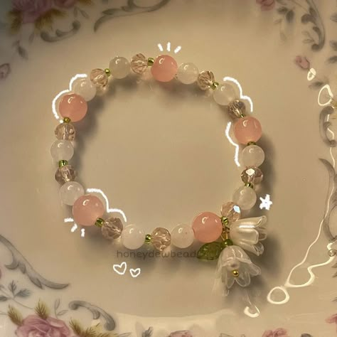 my lily of the valley bracelet 🪷 . . . . . . . . . . . #explore #explorepage #jewelry #beadwork #beads #beadsoup #charms #bracelets #etsy #etsyfinds #beadjewelry #beadbracelets #coquette #coquetteaesthetic #coquettefashion #coquettegirl #pastelaesthetic #lilyofthevalley #beadsbracelet #flowers Pink Cute Bracelet, Beaded Bracelets Coquette, Lily Of The Valley Bracelet, Coquette Bracelets, Bracelet Coquette, Lily Bracelet, Bracelets Etsy, Pretty Jewelry Necklaces, Bracelets Design