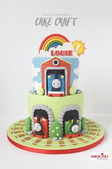 Two tier Thomas the Tank Engine cake with train models, a rainbow , sun and cloud. Cake With Train, Thomas Tank Engine Cake, Cloth Bangles, Thomas The Tank Cake, Thomas And Friends Cake, Thomas Birthday Cakes, Thomas The Tank Engine Cake, Thomas Train Birthday, Thomas Cake