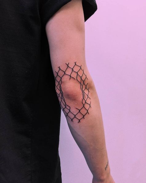 Broken fence tattooed around the right elbow by Tristan Ritter Elbow Piece Tattoo, Glass Shatter Tattoo Elbow, Barb Wire Elbow Tattoo, Knee Barbed Wire Tattoo, Net Tattoo, Fence Tattoo Design, Barbwire Heart Tattoo Elbow, Fence Tattoo, Broken Glass Elbow Tat