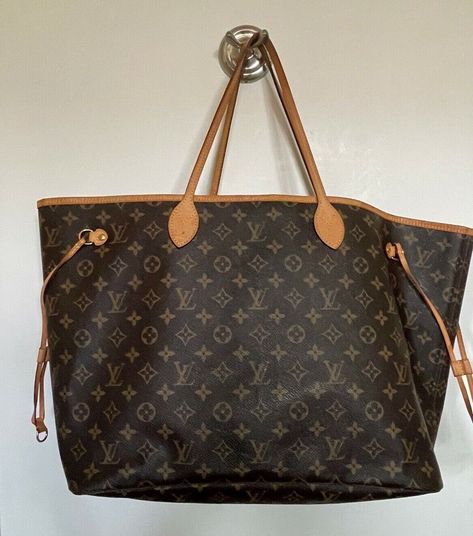 Preowned PrelovedLouis Vuitton Neverfull GM Description: We guarantee this is an authentic LOUIS VUITTON Monogram Neo Neverfull GM or 100% of your money back. This chic tote is finely crafted of signature Louis Vuitton monogram on coated canvas in the largest size. This shoulder bag features vachetta cowhide leather trim, shoulder straps, and side cinch cords with polished brass hardware. The wide top is open to a striped beige fabric interior with a hanging pocket. Detailed Features 15.7 x 13 x Louis Vuitton Neverfull Monogram, Neverfull Gm, Girly Bags, Stylish Handbags, Beige Fabric, Vuitton Neverfull, Louis Vuitton Bag Neverfull, Brass Hardware, Monogram Canvas