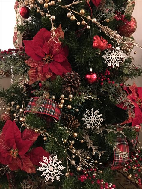 Traditional Christmas tree with poinsettias, red berries, snowflakes, pine cones and plaid ribbon Christmas Tree With Red Berries And Pine Cones, Red Poinsettia Christmas Decor, Christmas Tree Red Poinsettia, Poinsettia Christmas Tree Decorations, Poinsettia In Christmas Tree, Poinsettias On Christmas Tree, Red Poinsettia Christmas Tree, Red Tartan Christmas Tree, Christmas Tree With Poinsettia Flowers