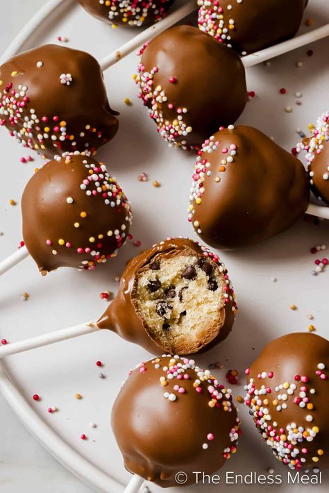 These eggless cookie dough cake pops are a marriage of childhood nostalgia and chocolatey fun. They take us back to childhood days spent sneaking spoonfuls from the mixing bowl. The only way to make cookie dough even better is to smother it in chocolate and deliver it to your mouth on a stick! Cookie Dough Cake Pops, Chocolate Cake Pops Recipe, Cookie Dough Pops, Make Cookie Dough, Oreo Cookie Cake, Eggless Cookie, Eggless Cookie Dough, Edible Cookie Dough Recipe, Cookie Dough Cake