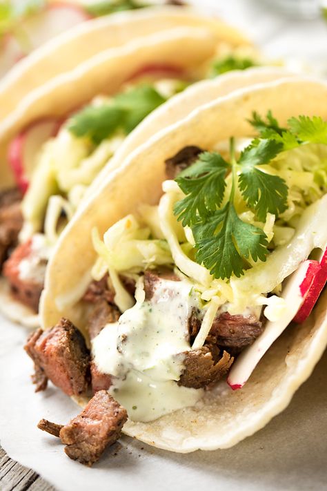 These steak tacos are deliciously juicy and zesty, topped with a citrusy slaw and mildly spicy and creamy jalapeno sauce! | thecozyapron.com #steaktacos #steaktacosrecipe #steaktacosmarinade #steaktacosrecipeseasy #steaktacoseasy Steak Taco Sauce, Steak Taco Recipe, Creamy Jalapeno Sauce, Steak Taco, Stomach Rumbling, Southwest Recipes, Creamy Jalapeno, Jalapeno Sauce, Yummy Bites