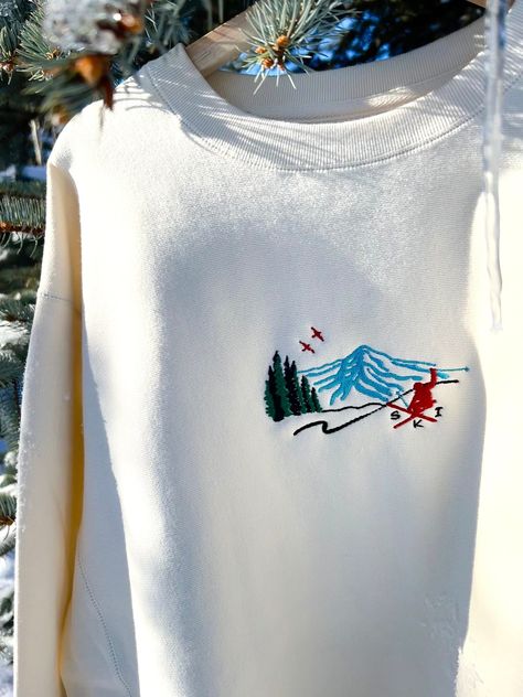 We sell primarily on our website where we offer faster turnaround and free shipping options.  TwinRavenCo Heavyweight Vintage Ski Scene Crewneck. 𓄿 Embroidered in our studio in Canada with sustainable threads 𓄿 Unisex- recommend to size down one size, please see size chart  𓄿 Reverse cover stitch sewing on all seams for durability and a premium finish 𓄿 Twill neck tape 𓄿 1 x 1 ribbing at neck, cuffs and waistband 𓄿 Double ribbing side panels for stretch 9oz 80% Cotton/20% Polyester 100% Cotton Face, 30 Singles * Check out our socials for discounts, new releases, and to see how we run our shop: TwinRavenCo Embroidery stabilizer is applied to the back of every embroidered item and is never to be removed. It is there to keep the stitches stable over time. This stabilizer naturally softe Cute Ski Clothes, Ski The East, Apres Ski Outfits, Sweater Embroidery, Stitch Sewing, Retro Ski, Embroidery Sweater, Ski Sweater, Vintage Ski