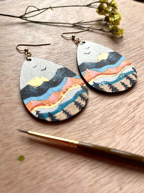 2 inch hand painted wooden tear drop earrings, painted mountains, sunset paimtimg, sunrise painting, mountain landscape painting, earring gifts, best gifts for her, boho jewelry, mountain lover gift, mountain aesthetic, faith can move mountains, 23 karat golf leaf, painted earrings, wooden earrings, mountain jewelry, mountain earrings, dangle earrings, colorful earrings, beautiful earrings, unique jewelry, unique earrings Artsy Hand Painted Everyday Earrings, Wooden Teardrop Earrings Diy, Gold Teardrop Earrings Hand Painted, Bohemian Hand Painted Brown Earrings, Hand Painted Earrings Wood, Wooden Handpainted Earrings, Nature-inspired Hand Painted Drop Earrings, Mountain Earrings, Mountain Jewelry