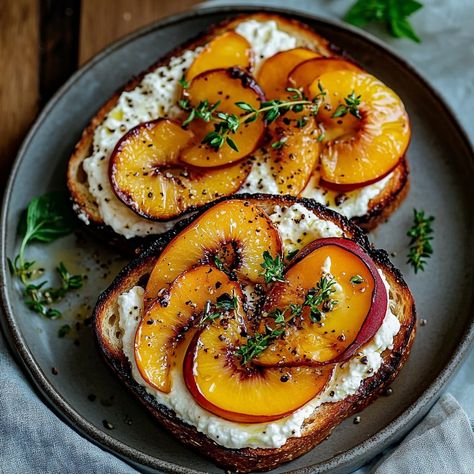 Grilled Peach Ricotta Toast 🍑🍞 Elevate your toast game with this delightful Grilled Peach Ricotta Toast! Perfect for a sophisticated breakfast or a light lunch, this dish features juicy grilled peaches paired with creamy ricotta cheese and a hint of honey. Ingredients: • 2 slices of sourdough bread 🍞 • 1 large peach, sliced 🍑 • 1/2 cup ricotta cheese 🧀 • 1 tablespoon honey 🍯 • Fresh thyme sprigs 🌿 • Olive oil for drizzling 🌿 • Salt and pepper to taste 🧂 Instructions: 1. Prepare the Peaches: o... Peach Toast, Peach Ricotta, Ricotta Toast, Grilled Peaches, Honey Roasted, Light Lunch, Fresh Thyme, Ricotta Cheese, Instagram Food