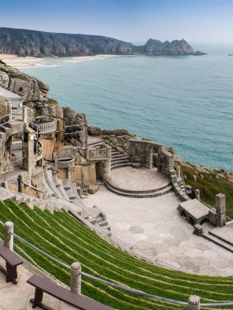 Carved into granite cliffs high above the sea of Porthcurno Bay, a performance at this open-air theatre in Cornwall is a unique experience. #travel #uktravel Outdoor Theatre, Open Air Theater, Globe Theater, Cornwall Uk, Outdoor Theater, Royal Park, Ancient Buildings, London Park, The Cloisters